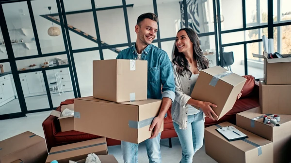 A couple holding several moving boxes