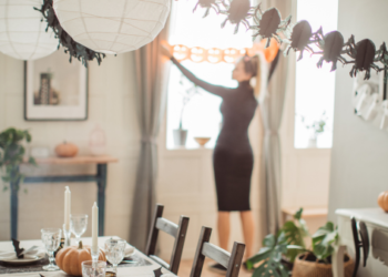 A woman putting up Halloween decorations.