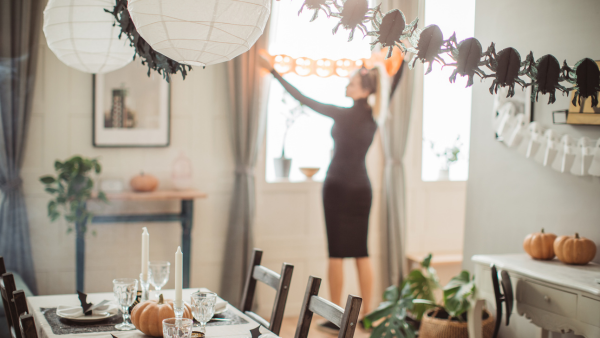 A woman putting up Halloween decorations.
