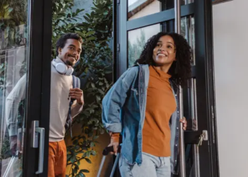 Two people walking into a home.