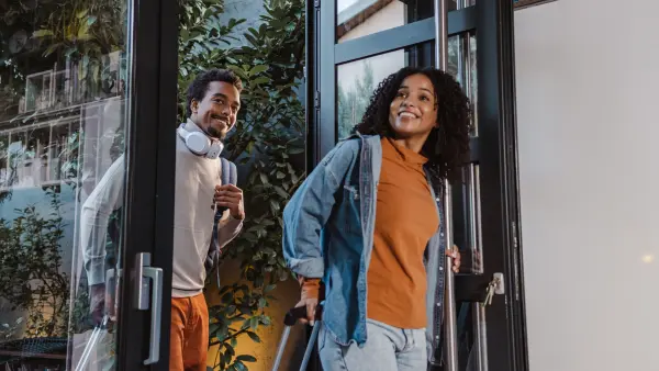 Two people walking into a home.