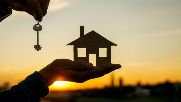 Someone holding a pair of keys and a home