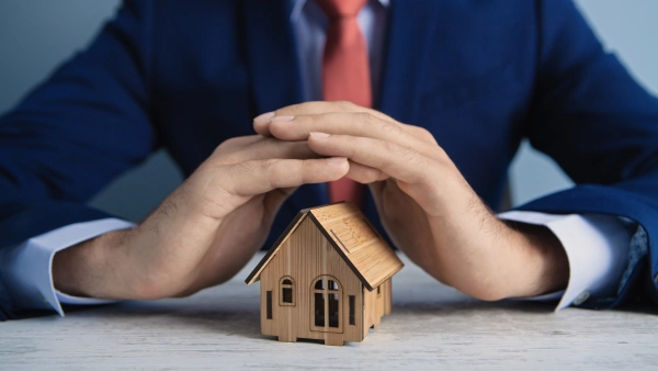 Hands protecting a tiny house