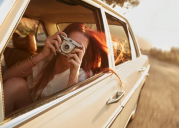 Person holding a camera in a car.