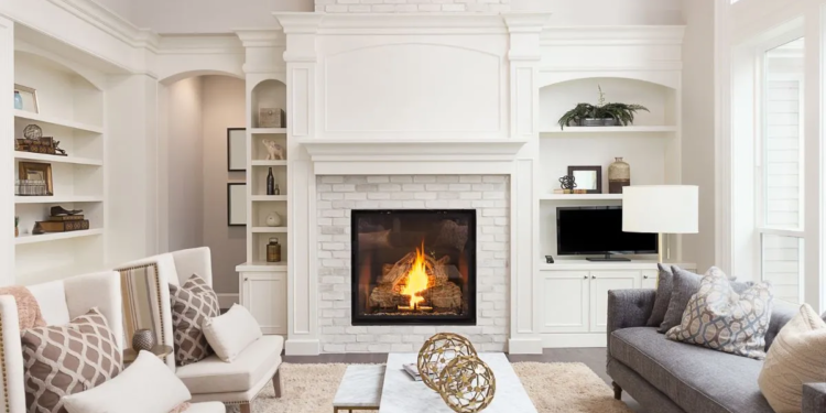 White spacious living room with a couch, two accent chairs and a fireplace
