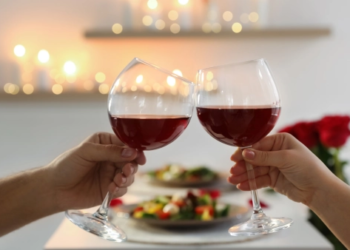 Two glasses of wine cheering together.