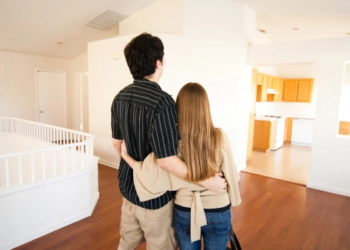 Two new homeowners hug each other in their new home