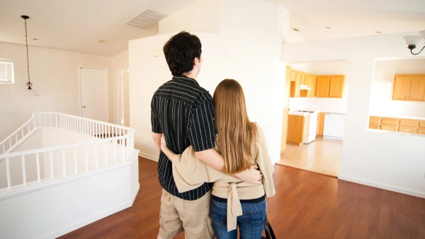 Two new homeowners hug each other in their new home