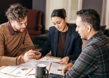 A couple looks at financial documents with an advisor