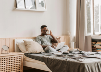 Person drinking coffee in a bed