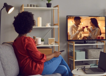 A woman watching a reality tv show in her living room.