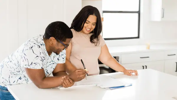 Couple signing papers to a new home in kitchen
