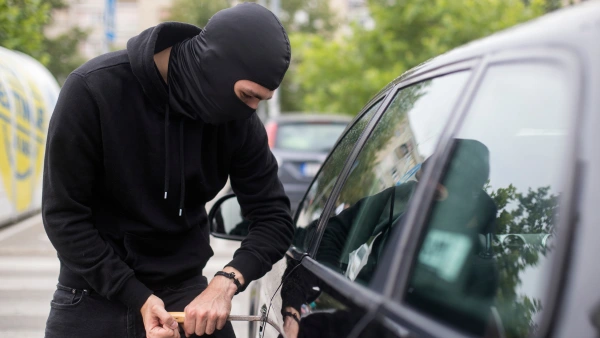 A thief trying to get into a car