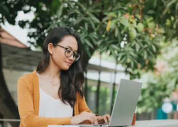 Woman working on laptop outside