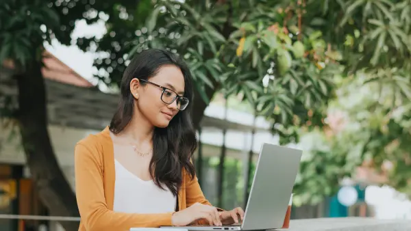 Woman working on laptop outside