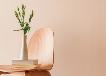 A chair with books and a vase resting on it