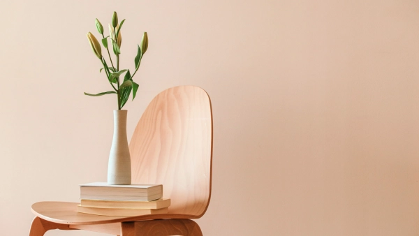 A chair with books and a vase resting on it