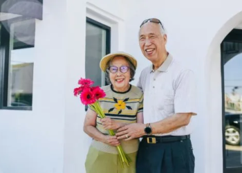Smiling senior couple outside house