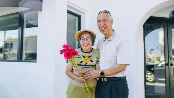 Smiling senior couple outside house