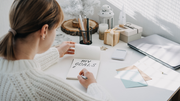 A woman writing out her goals at her desk