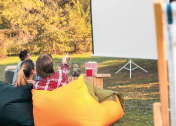 People sitting and enjoying a movie outdoors.
