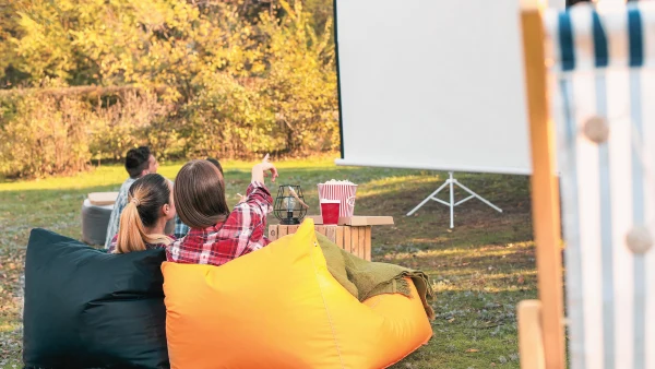 People sitting and enjoying a movie outdoors.