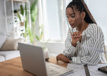 A young woman looking at a laptop