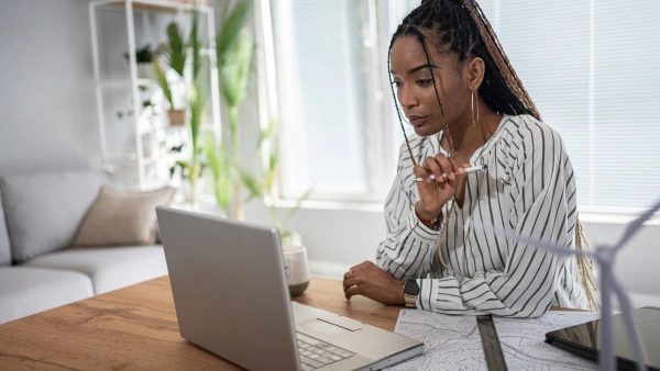A young woman looking at a laptop