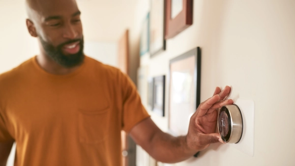 A man adjusting a smart thermostat