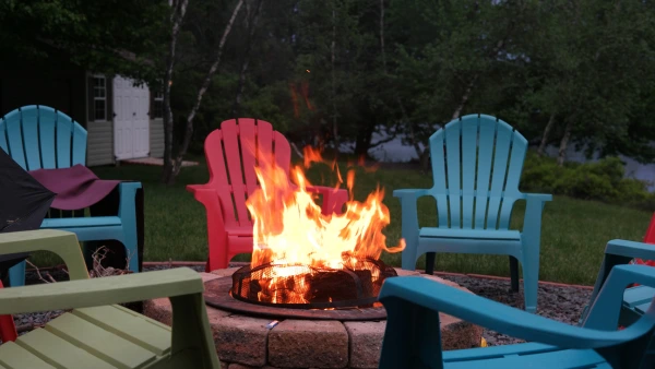 A backyard fire pit surrounded by chairs