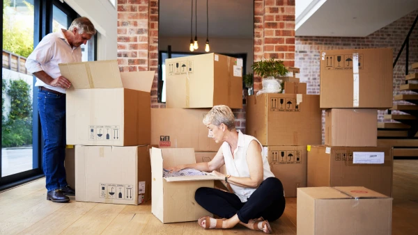 A couple packs up moving boxes in their home