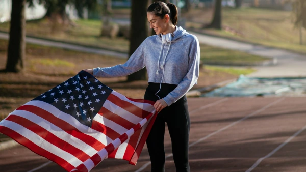 An athlete holding USA flag.