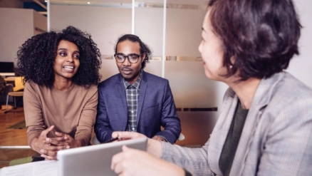 Two people talking to a financial advisor.