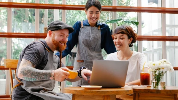 baristas looking at a laptop in a coffee shop
