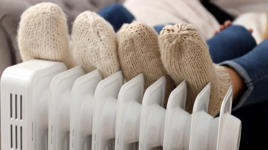 2 pairs of feet being warmed up by a heater.