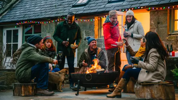 An outdoor fire pit surrounded by a group of people.