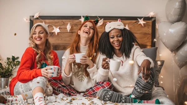 Friends celebrating the holidays in a decorated bedroom.