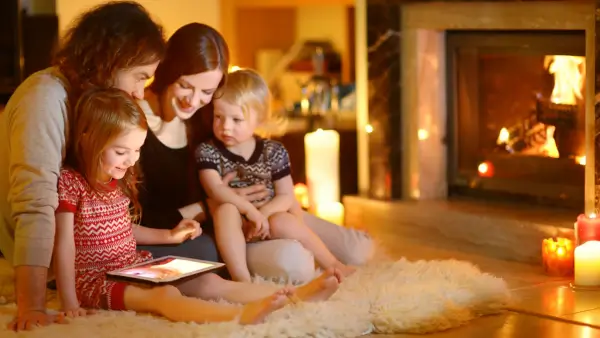A family spending time with each other near a fireplace.