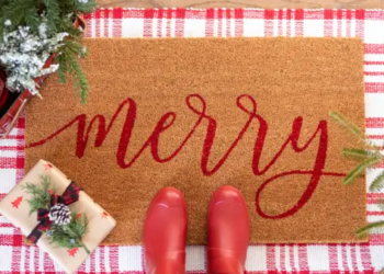 A winter mat that says "Merry" in red cursive writing.