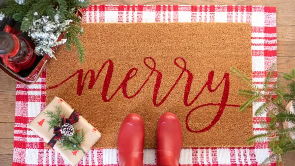 A winter mat that says "Merry" in red cursive writing.