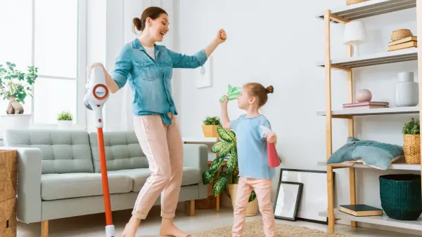 An adult and a child cleaning a room together.