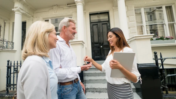 Two people talking to a real estate agent.