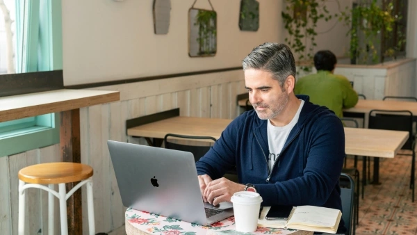 man on laptop in a coffee shop