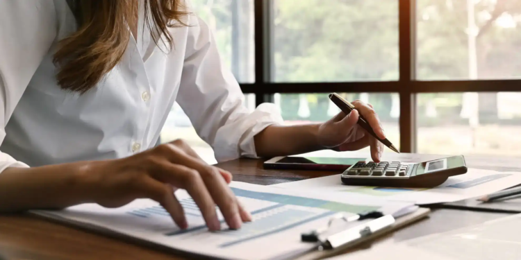 A woman looking at her finances with a calculator.