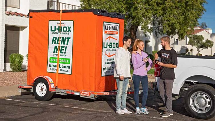 A couple stands next to a Moving Help Service Provider who delivered the couple’s U-Box container to their apartment