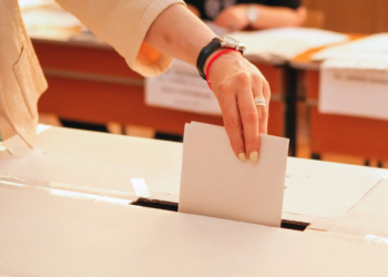 Someone casting a vote into a box.