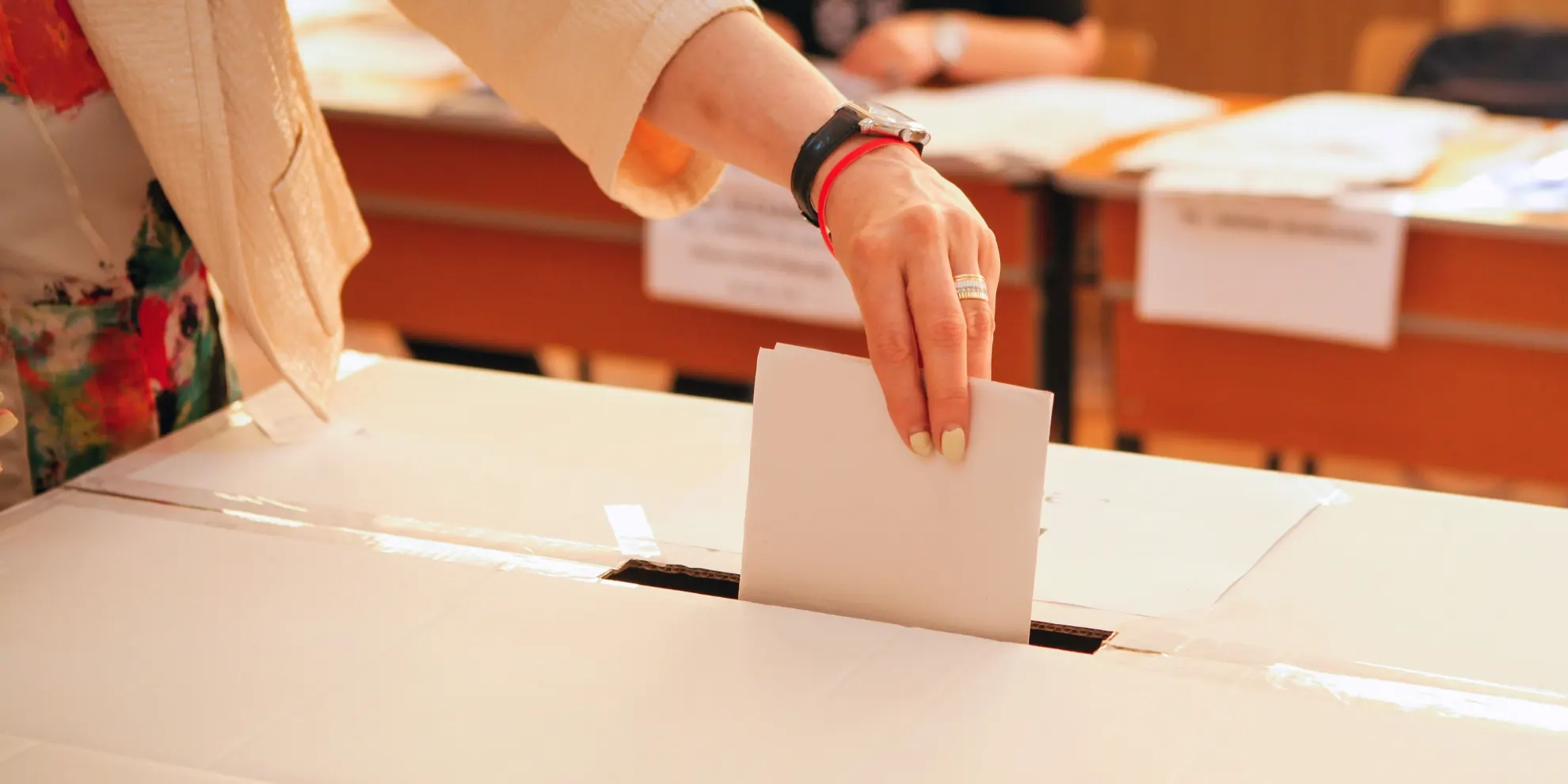 Someone casting a vote into a box.