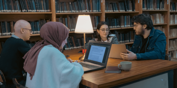 Group of students studying together in the library.