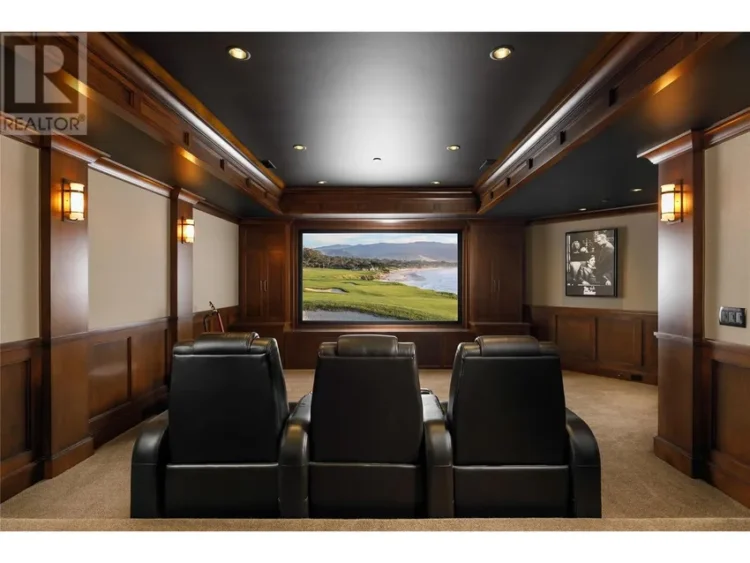 A home theater featuring three recliners facing a large screen.