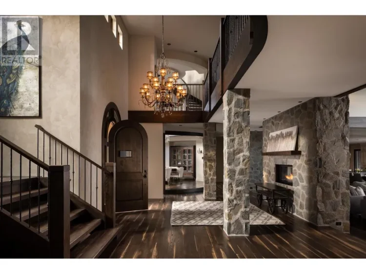 A grand entryway featuring stone walls and an elegant chandelier.